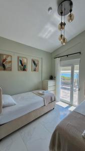 a bedroom with two beds and a large window at Platan Paradise in Maronia +59 photos