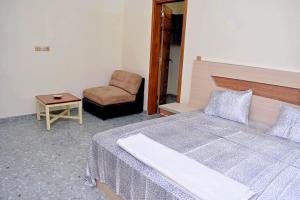 a bedroom with a bed and a chair and a table at Residence LaFina in Saly Portudal