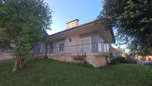 a house with a balcony on top of a yard at Aveiro, Veneza Portuguesa in Oliveirinha