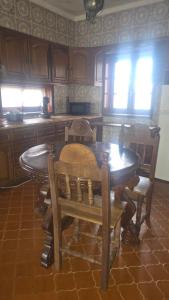 a kitchen with a wooden table and chairs and windows at Aveiro, Veneza Portuguesa in Oliveirinha