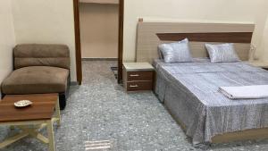 a bedroom with a bed and a chair at Residence LaFina in Saly Portudal