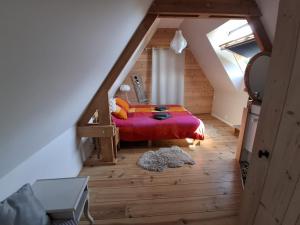 a attic room with a bed and a staircase at Chez les Wawas in Sainte-Agathe-dʼAliermont