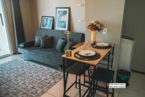 a living room with a table and a blue couch at VIVA - Centro - Garagem - Apt 1 Dormitório in Santa Maria
