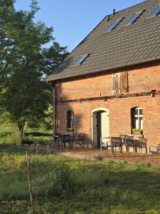 a brick building with tables and chairs in front of it at Dom w Młodzianowie in Milicz