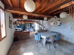 a dining room with a table and blue chairs at Chez les Wawas in Sainte-Agathe-dʼAliermont