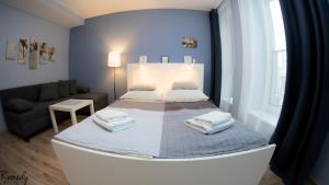 1 dormitorio pequeño con 1 cama y 1 sofá en Apartamenty Sedinum - Bryza, en Szczecin