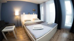 シュチェチンにあるApartamenty Sedinum - Bryzaのベッドルーム1室(ベッド1台、タオル2枚付)