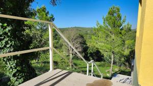 a balcony with a view of a forest of trees at Cabañas Elementos in Huerta Grande