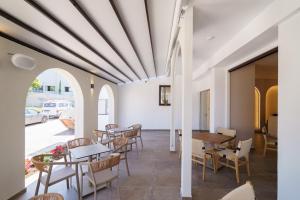ein Esszimmer mit Tischen und Stühlen und einer Decke in der Unterkunft Noema Hotel in Syvota