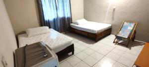 a small room with two beds and a mirror at Casa de Descanso - Camelia in Monte Gordo