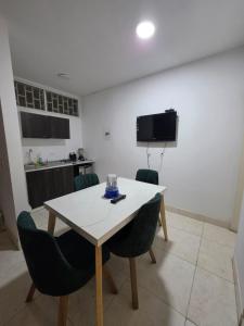 a dining room with a table and chairs and a kitchen at EDIFICIO BENHUr in Cúcuta