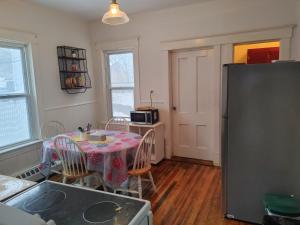 a kitchen with a table and a refrigerator at Cozy Tree House in Saint John +18 photos