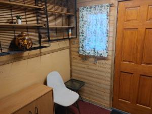 a room with a white chair and a window at Cozy Tree House in Saint John