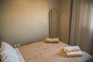 a bedroom with a bed with two towels on it at VIVA - Centro - Garagem - Apt 1 Dormitório in Santa Maria