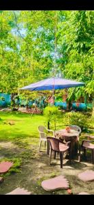 a picnic table with a blue umbrella in a park at Rancho María in San Diego