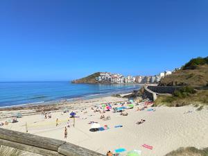 a group of people on a beach near the ocean at Las gaviotas,playa,piscinayparking in Malpica