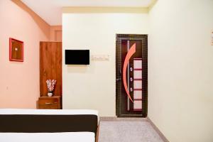 a room with a bed and a wall with a picture at Hotel O New Star Guest House in Behāla +20 photos