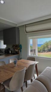 a dining room with a table and chairs and a window at Platan Paradise in Maronia