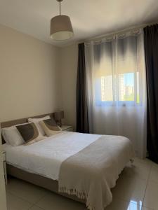 a bedroom with a large bed and a window at appartement privé exceptionnel in Netanya