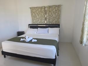 a bedroom with a bed with two stuffed animals on it at Ackee Haven Comfortable Spacious Home in Poor Mans Corner
