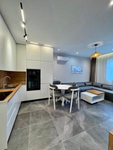 a kitchen and living room with a table and a couch at Apartamente Antoni Shengjin2 in Shëngjin