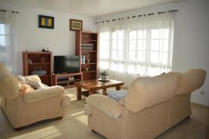 a living room with two chairs and a tv at Agra Boa in Bornalle