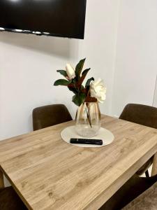 a vase of flowers sitting on a wooden table at A casa di Cetta in Melendugno