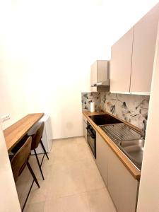 a kitchen with white cabinets and a wooden table at A casa di Cetta in Melendugno