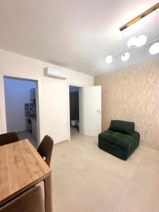 a living room with a green chair and a table at A casa di Cetta in Melendugno +1 photo