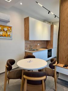 a kitchen with a table and chairs and a sink at Apartamente Antoni Shengjin2 in Shëngjin