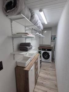 a small kitchen with white shelves and a microwave at Ferienwohnung Agava in Michelstadt