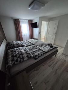 a bedroom with a large bed with a wooden floor at Ferienwohnung Agava in Michelstadt