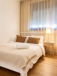 a white bed in a bedroom with a window at אמור in Beer Sheva