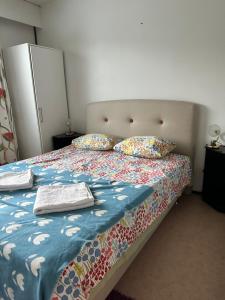 a bed with two pillows and a blanket on it at Kätevä Koti Keskustassa in Ähtäri