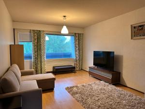 a living room with a couch and a television at Kätevä Koti Keskustassa in Ähtäri
