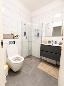 a white bathroom with a toilet and a sink at אמור in Beer Sheva