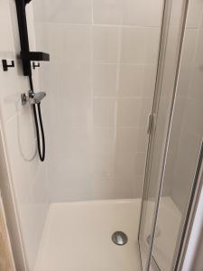 a shower stall with a glass door with a shower at Chambre du petit figuier in Aramon