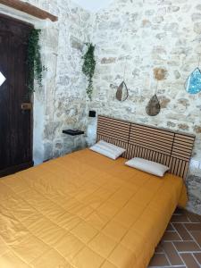 a bedroom with a bed in a stone wall at Chambre du petit figuier in Aramon