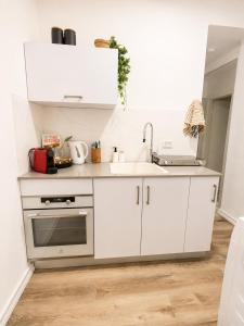 a kitchen with white cabinets and a sink at אמור in Beer Sheva