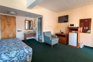 a hotel room with a bed and a sink at Travelers Inn by OYO Longview Kelso in Longview