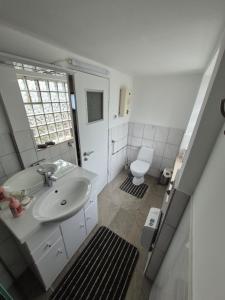 a white bathroom with a sink and a toilet at Ferienwohnung Agava in Michelstadt +9 photos