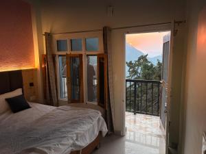 a bedroom with a bed and a balcony with a view at Anamika Forest View 1RK Near Kempty Falls Mussoorie in Mussoorie