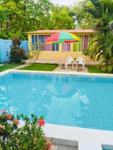a pool with a table and a colorful umbrella at Rancho María in San Diego +9 photos