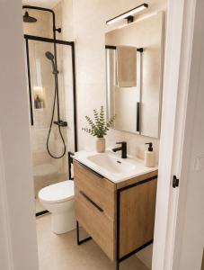 a bathroom with a sink and a toilet and a shower at La casa Suiza in Cercedilla +2 photos