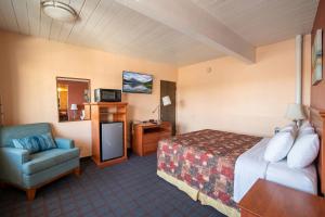 a hotel room with a bed and a chair at Travelers Inn by OYO Longview Kelso in Longview +19 photos