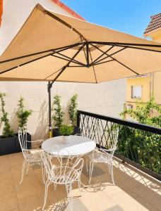 a table and chairs under a large umbrella on a balcony at La casa Suiza in Cercedilla