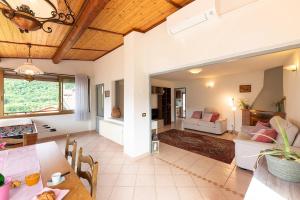 a dining room and living room with a table and chairs at Puria Rustic Lake View Apartment in Valsolda