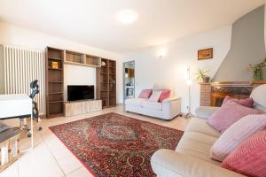 a living room with a couch and a tv at Puria Rustic Lake View Apartment in Valsolda