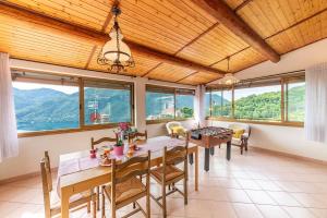 a dining room with a table and chairs and windows at Puria Rustic Lake View Apartment in Valsolda