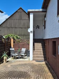 a patio with chairs and a table next to a building at Ferienwohnung Agava in Michelstadt